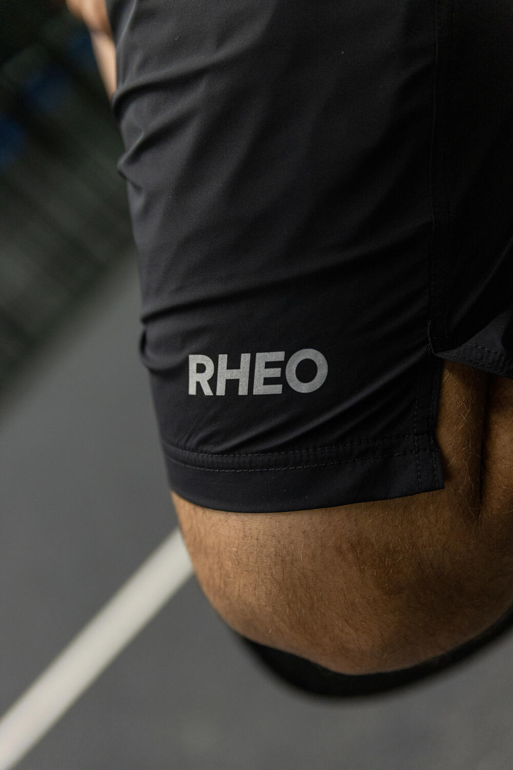 Close-up of the reflective RHEO logo on ClayShell shorts