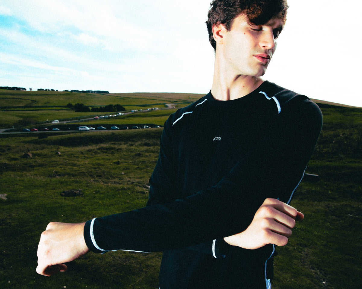 Athlete in a black CryoSilk top with reflective piping on Peak District moorland